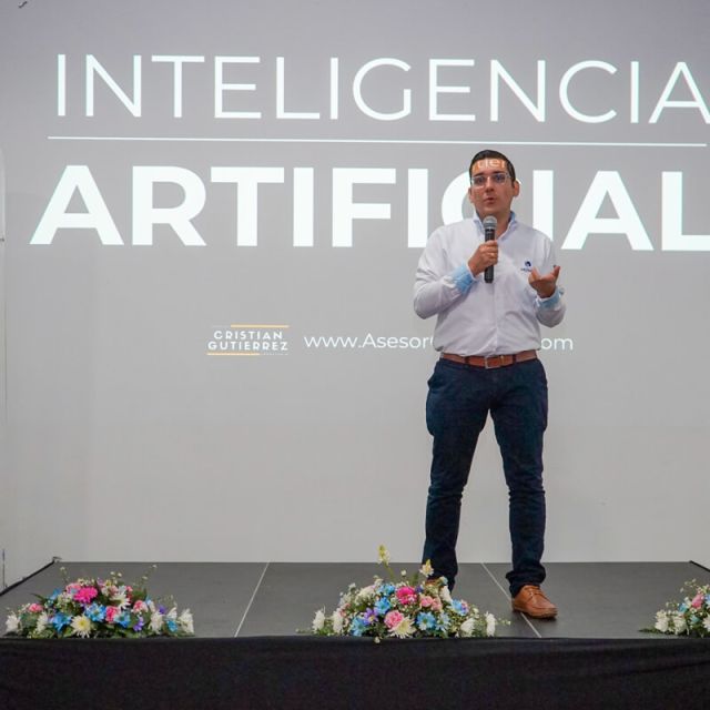 Conferencista presenta una charla sobre inteligencia artificial en un evento empresarial de Cajasan, frente a una pantalla con el título “Inteligencia Artificial”