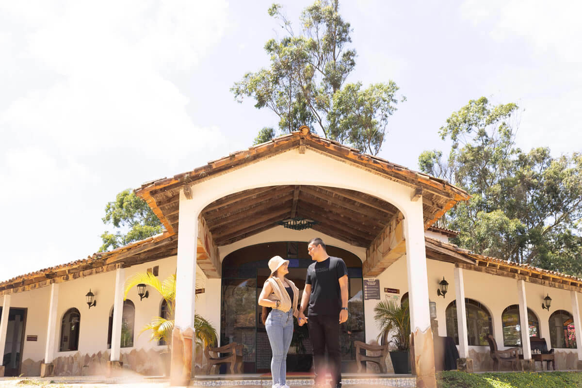 Pareja en entrada colonial de acuarela, rodeados de naturaleza