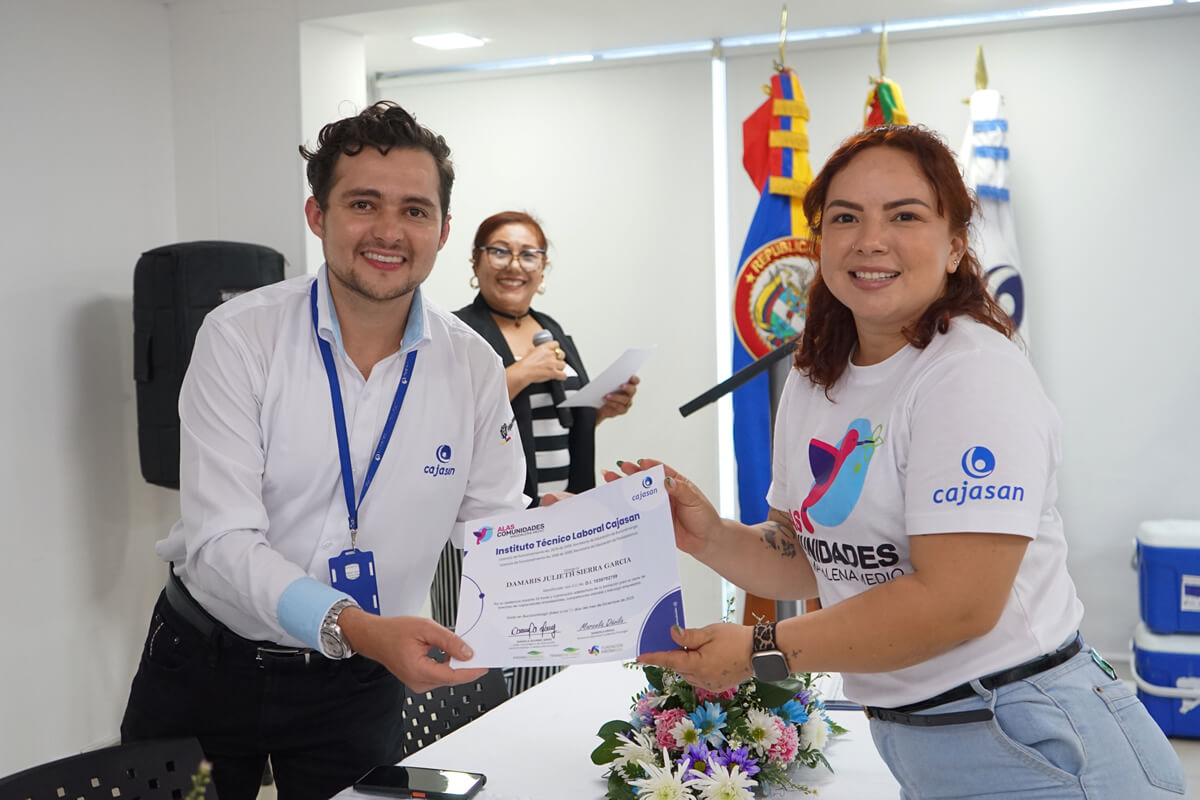 Colaborador de Cajasan entrega certificado a una mujer emprendedora durante jornada de certificación del programa Alas Comunidades