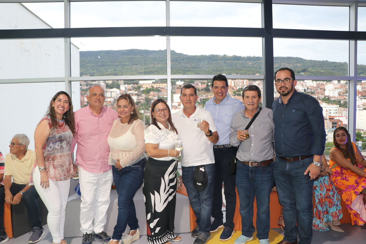 Grupo de personas sonríe y brinda durante la inauguración del Parque Cajasan San Gil, con vista panorámica de la ciudad al fondo