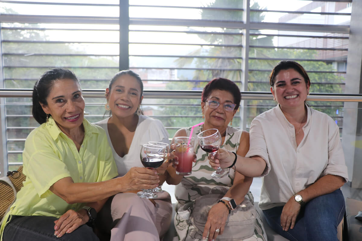 Grupo de mujeres sonrientes brindando con copas y bebidas durante la inauguración del Parque Cajasan San Gil