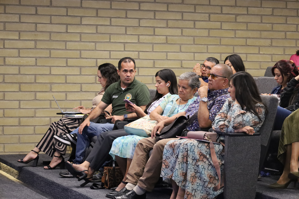 Grupo de asistentes sentados en un auditorio observando una presentación durante un evento institucional