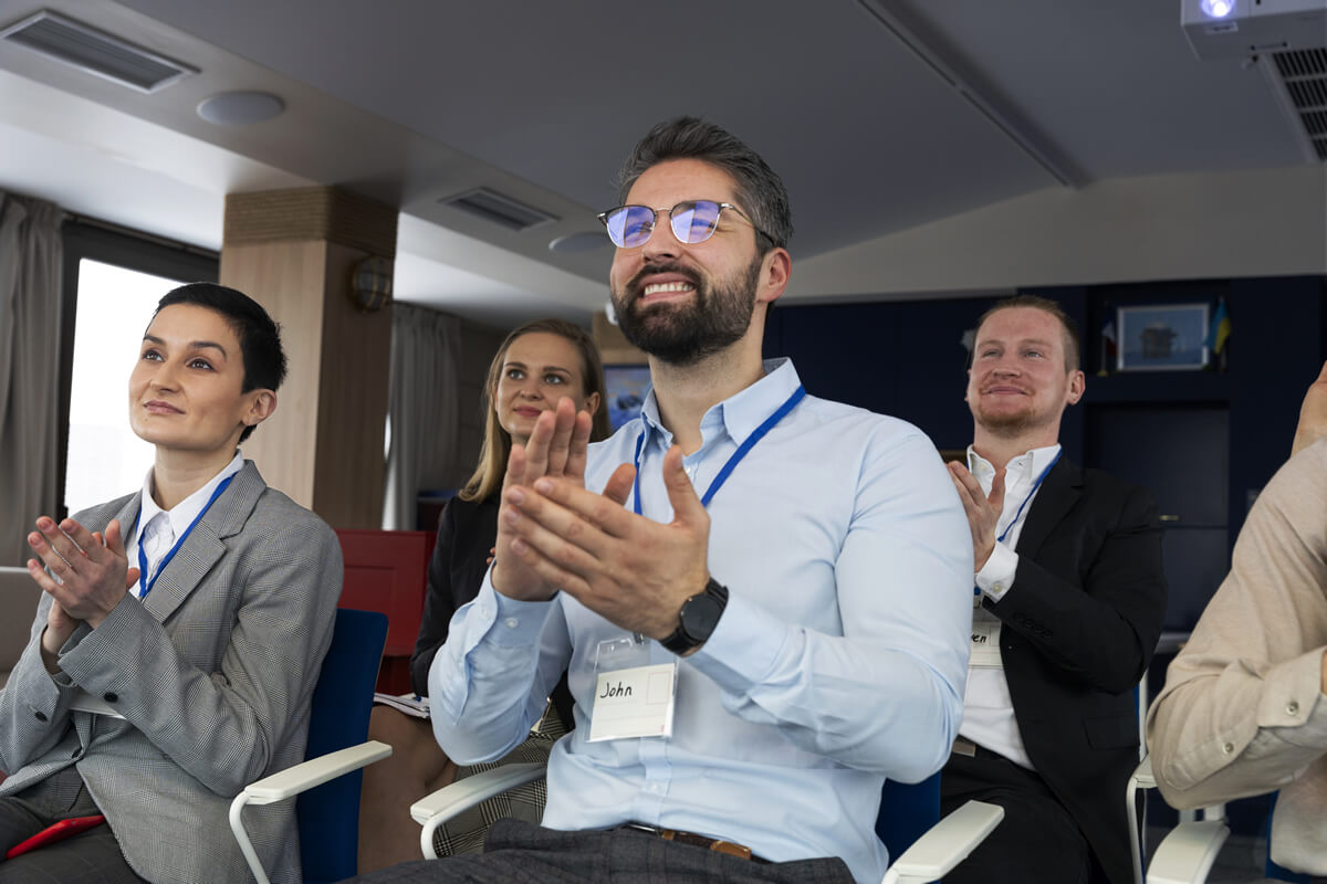 Personas aplaudiendo en un evento académico o empresarial