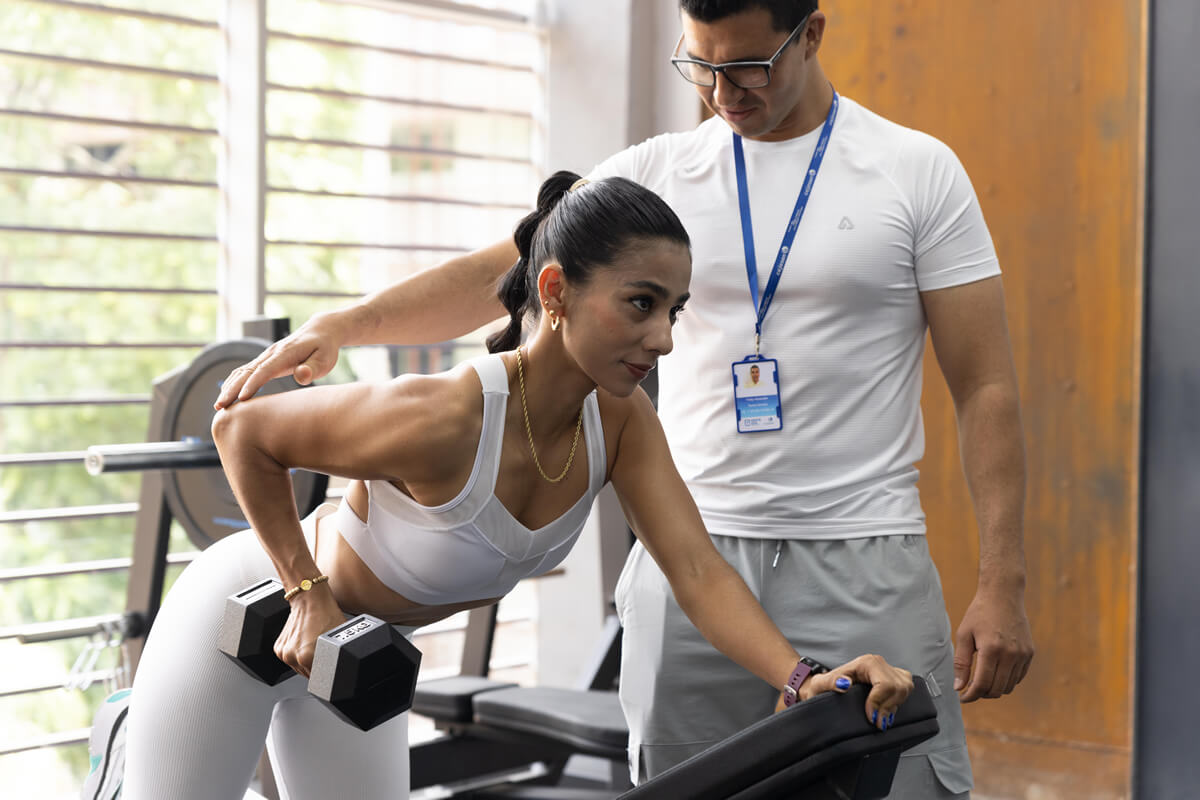 Entrenador y usuaria durante sesión de entrenamiento en el gimnasio del Parque Cajasan San Gil